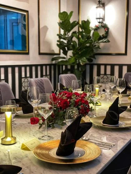 A private dining table styled with flowers and gold charger plates