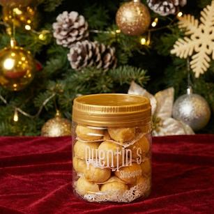 Jar of Pineapple tarts in front of a christmas tree