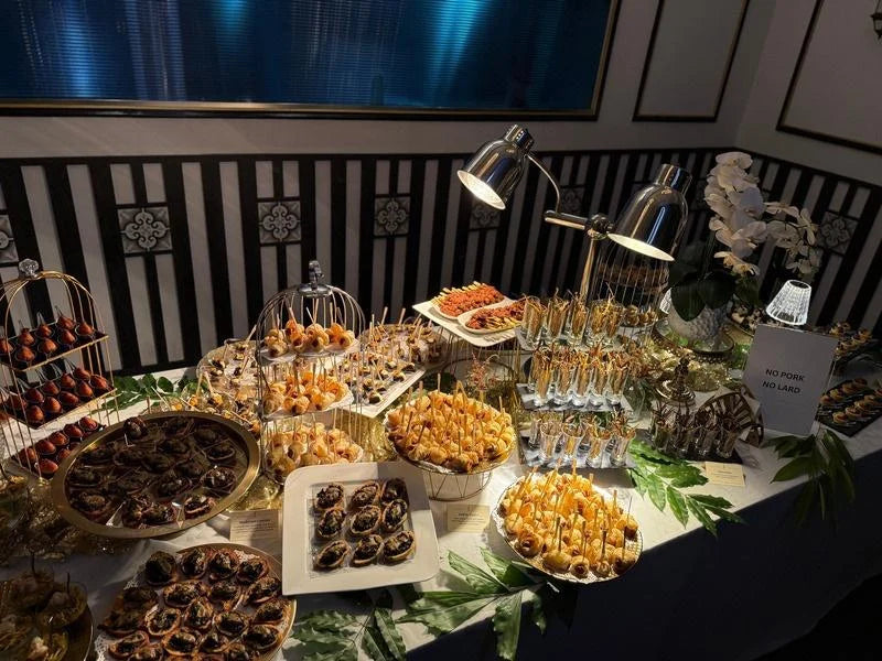 Quentin’s canapé grazing table with tiered stands and an assortment of food